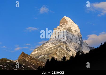 Weiße Wolken bilden sich über dem ikonischen Matterhorn-Berg, von Zermatt aus gesehen, Wallis, Schweiz Stockfoto