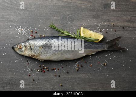 Heringsfische und Gewürze auf grauem Holzhintergrund Stockfoto