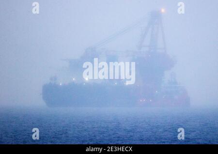 Nienhagen, Deutschland. Januar 2021. Das russische Rohrverlegungsschiff "Fortuna" ist in der Ostsee vor dem Hafen von Rostock verankert, kaum sichtbar im Nebel und Schneeregen. Das Spezialschiff soll für Bauarbeiten an der deutsch-russischen Nord Stream 2 Ostsee-Gaspipeline eingesetzt werden. Die USA wollen erstmals Sanktionen gegen die Gaspipeline verhängen. Die Strafmaßnahmen betreffen das russische Laienschiff "Fortuna", das am Bau der Pipeline beteiligt ist. Quelle: Jens Büttner/dpa-Zentralbild/dpa/Alamy Live News Stockfoto