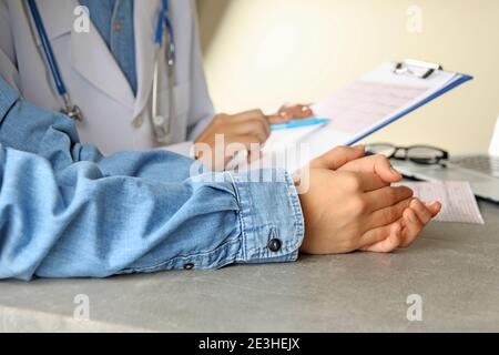 Ärztin, die die Ergebnisse des Elektrokardiogramms mit dem Patienten überprüft Stockfoto