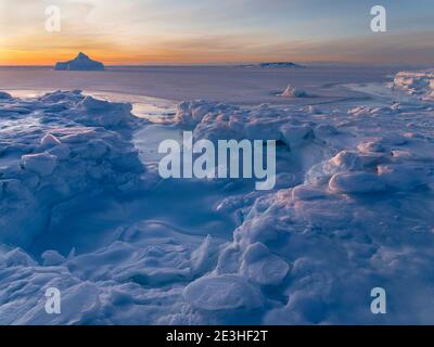 Sonnenuntergang am Ufer der gefrorenen Disko Bay. Disko Bay im Winter, Westgrönland. Amerika, Nordamerika, Grönland, Dänemark Stockfoto