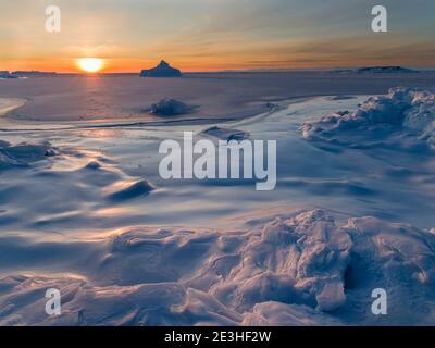 Sonnenuntergang am Ufer der gefrorenen Disko Bay. Disko Bay im Winter, Westgrönland. Amerika, Nordamerika, Grönland, Dänemark Stockfoto