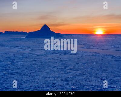 Sonnenuntergang am Ufer der gefrorenen Disko Bay. Disko Bay im Winter, Westgrönland. Amerika, Nordamerika, Grönland, Dänemark Stockfoto