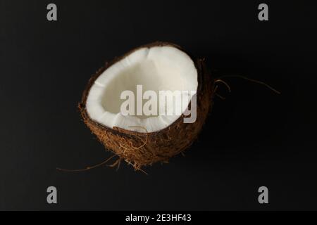 Die Hälfte der frischen Kokosnuss auf schwarzem Hintergrund Stockfoto