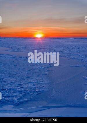 Sonnenuntergang am Ufer der gefrorenen Disko Bay. Disko Bay im Winter, Westgrönland. Amerika, Nordamerika, Grönland, Dänemark Stockfoto