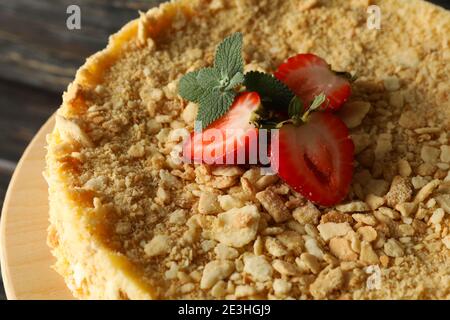 Stand mit Napoleon Kuchen mit Erdbeere auf Holzhintergrund Stockfoto
