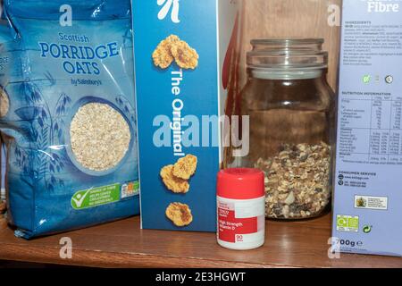 Eine Reihe Frühstückscerealien plus eine Flasche Vitamin D Pillen auf einem Regal in einer heimischen Küche in Oldham, Großbritannien. Stockfoto