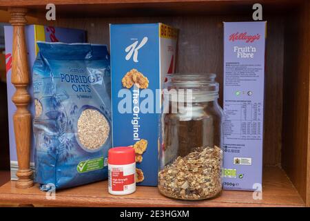 Eine Reihe Frühstückscerealien plus eine Flasche Vitamin D Pillen auf einem Regal in einer heimischen Küche in Oldham, Großbritannien. Stockfoto