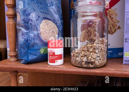 Eine Reihe Frühstückscerealien plus eine Flasche Vitamin D Pillen auf einem Regal in einer heimischen Küche in Oldham, Großbritannien. Stockfoto