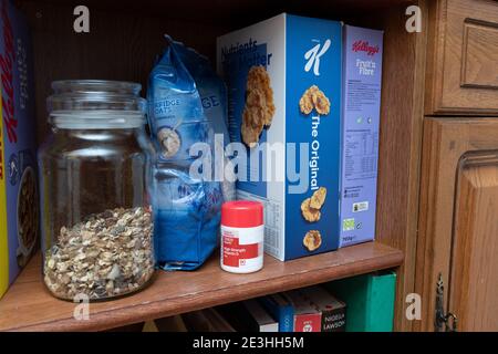 Eine Reihe Frühstückscerealien plus eine Flasche Vitamin D Pillen auf einem Regal in einer heimischen Küche in Oldham, Großbritannien. Stockfoto