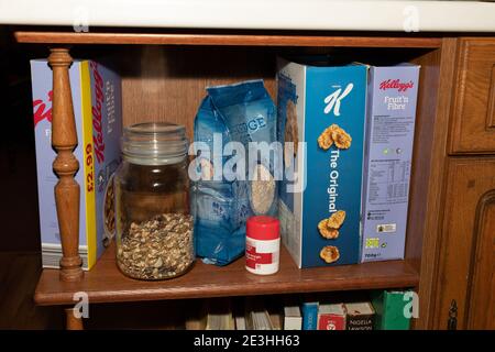 Eine Reihe Frühstückscerealien plus eine Flasche Vitamin D Pillen auf einem Regal in einer heimischen Küche in Oldham, Großbritannien. Stockfoto