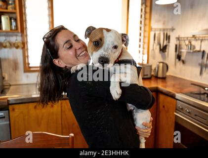 Selbstbewusste Frau lieben und kuscheln ihren niedlichen Haustier Hund genießen das Leben zu Hause zusammen. Positives Bild von Coronavirus Ausbruch zu Hause bleiben sicher und ein Stockfoto