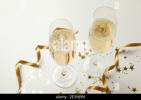 Zwei Champagnergläser mit goldenem Glitzer auf Weiß, ein heller Champagner-Prost fürs neue Jahr Stockfoto