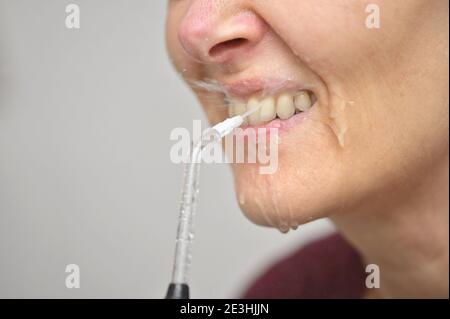 Porträt EINER jungen Frau und professionelle Oral Irrigator oder Flosser Stockfoto