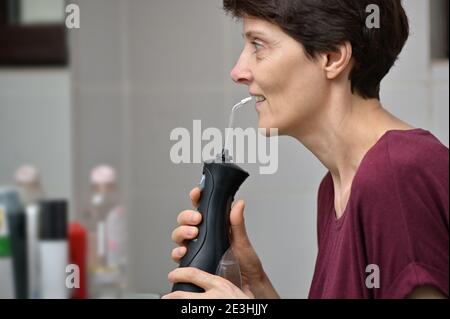 Porträt EINER jungen Frau und professionelle Oral Irrigator oder Flosser Stockfoto