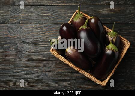 Korb mit frischen Auberginen auf Holzhintergrund Stockfoto