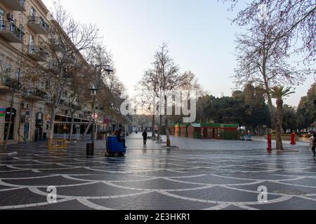 Industrielle Straßenkehrmaschine beim Putzen einer Stadtstraße in Baku - Aserbaidschan: 2. Januar 2021. Straßenreinigungsmaschine im Park. Stockfoto