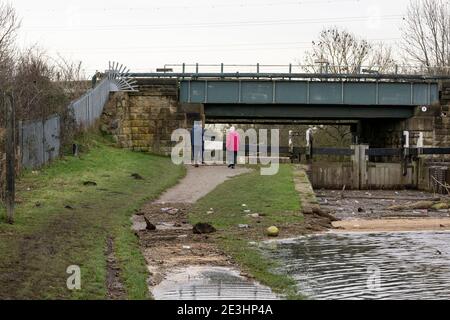 Altes Paar, das einen überfluteten Kanal entlang läuft Stockfoto