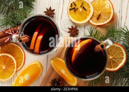 Becher mit Glühwein mit Orangenscheiben und Zutaten auf Holz, ein rustikaler Winterglühwein in einer Top-Down-Ansicht Stockfoto