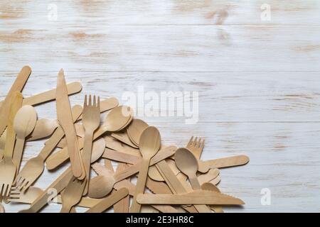 Holzbesteck auf Holzhintergrund. Einwegbesteck, Geschirr. Umweltschutz, Natur sparen, Ökologie plastikfrei, Zero Waste Konzept. Nein Stockfoto