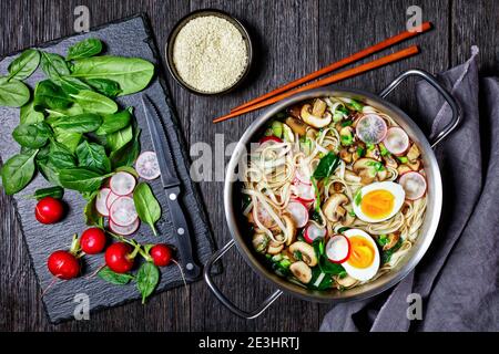 Udon Nudelsuppe asiatische Gericht von Kakejiru Brühe auf Basis von Dashi, Sojasauce und Mirin mit Spinat, Rettich, weich gekochte Eier, in Scheiben geschnittene Pilze serviert auf einem Stockfoto