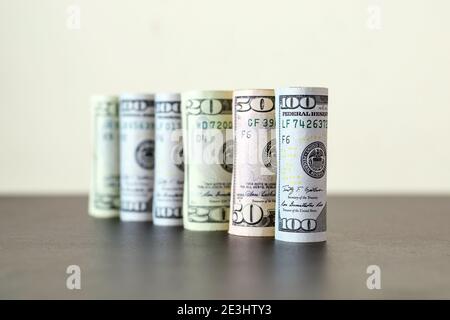 Gruppe von Dollar rollt in einem Kreis auf dem Tisch, Konzepte für Wirtschaft und Finanzen. Stockfoto