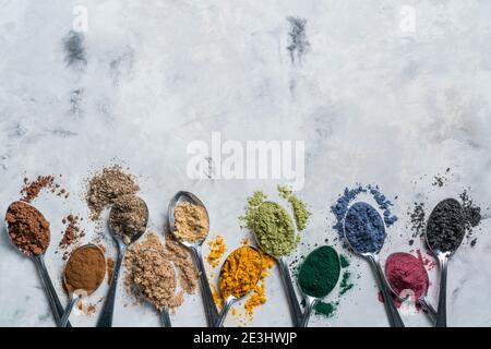 Super Pulver in Löffel - Matcha, Kurkuma, Ingwer, Kakao, Spirulina, Chia, Zimt, schwarzer Sesam Stockfoto