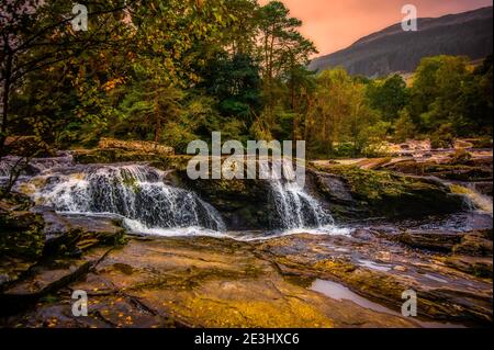 Die Falls of Dochart liegen am Fluss Dochart bei Killin in Stirling, Schottland, am westlichen Ende von Loch Tay. Eine Brücke über den Fluss AS Stockfoto
