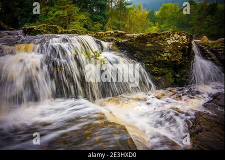 Die Falls of Dochart liegen am Fluss Dochart bei Killin in Stirling, Schottland, am westlichen Ende von Loch Tay. Eine Brücke über den Fluss AS Stockfoto