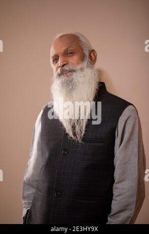 EIN BÄRTIGER ALTER MANN STEHT UND DENKT Stockfoto