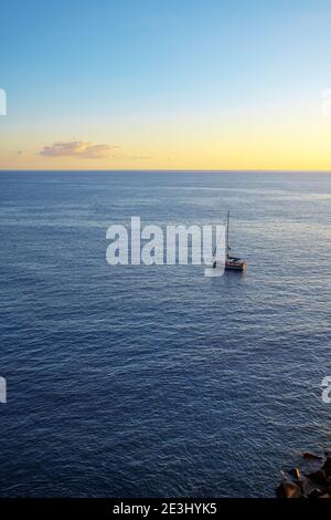 Einsame Yacht vor Anker in der Nähe Playa San Juan Strand, Blick von oben auf den weichen bunten Sonnenuntergang, Horizont Linie und tiefblaues Wasser, Playa San Juan Stockfoto