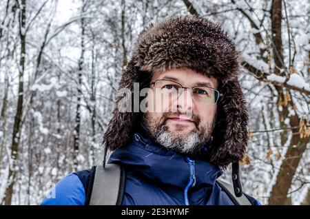 Portrait Nahaufnahme eines mddle gealterten Mannes mit grau Bart in einem verschneiten Winterwald Stockfoto