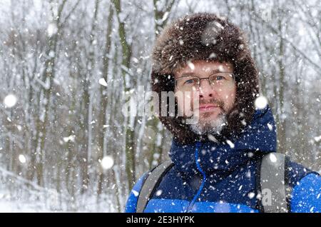 Portrait Nahaufnahme eines mddle gealterten Mannes mit grau Bart in einem verschneiten Winterwald Stockfoto