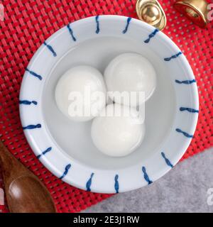 Draufsicht auf große tangyuan Yuanxiao (klejeous Reis Knödel Bälle) für chinesische Lunar Neujahr Festival Essen, Worte auf der goldenen Münze bedeutet die Dynastie Stockfoto