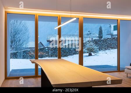 Innen ein Esszimmer, mit einem großen Erker, niemand innen und außen gibt es Schnee Stockfoto