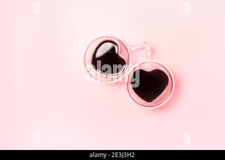 Zwei niedliche herzförmige Kaffeetassen auf rosa Hintergrund mit Copy Space. Valentines Day Flatlay Komposition. Stockfoto