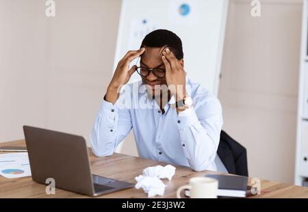 Verzweifelter afroamerikanischer Manager, der unter Burnout leidet Stockfoto