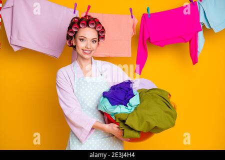 Portrait von attraktiven fleißigen fröhlichen Mädchen halten in der Hand schmutzig Tragen Dinge isoliert hell orange Farbe Hintergrund Stockfoto