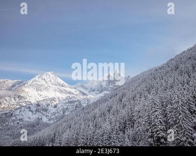 Schwerer Schnee bedeckt die Berge und die Berge von Chamonix in Frankreich. Ein Langlaufläufer schnitzt einen Weg durch den tiefen Schnee im Wald auf einem perfekten Stockfoto