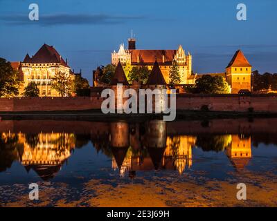 Malbork Schloss bei Nacht mit Reflexion in Nogat Fluss, Polen Stockfoto