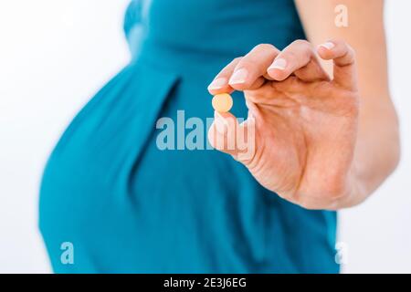Schwangere Frau hält Nahrungsergänzungsmittel in der Hand Stockfoto