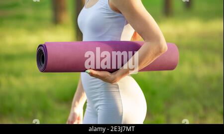 Weibliche Hände Abrollen Yogamatte vor dem Training Übung. Workout Stockfoto