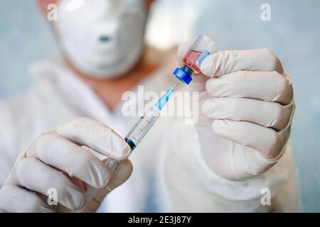 Professioneller Arzt mit medizinischer Spritze in den Händen, immer bereit für die Injektion. Medizinisches Konzept. Massenimpfung gegen saisonale Krankheiten, Grippe Stockfoto