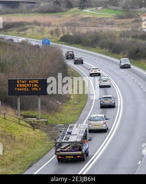 Weymouth, Dorset, Großbritannien. Januar 2021. Eine Reihe von Fahrzeugen passieren ein Schild mit "Stay Home Essential Travel Only" auf der A354 in Weymouth in Dorset während der Covid-19-Sperre. Bild: Graham Hunt/Alamy Live News Stockfoto