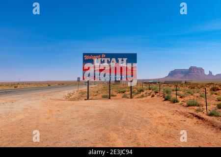 Utah, USA - 17. Juli 2014: Ein Schild des Bundesstaates Utah, das den US Highway 163, der zum Monument Valley führt, mit Sandsteinpfäpfeln im Hintergrund abfährt Stockfoto