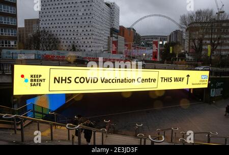 London, Großbritannien. Januar 2021. Schild an der Wembley Park Station, die die Öffentlichkeit zum Impfzentrum führt. NHS Impfzentrum in Wembley. Das NHS-Impfzentrum im Olympic Office Center, im Schatten des Wembley-Stadions an der Fulton Road, begrüßte seine ersten Patienten am Montagmorgen, dem 18. Januar. Es ist einer von 25 neuen Standorten, die diese Woche in London eröffnet werden, und bringt die Gesamtzahl der Impfstellen in der Hauptstadt auf 170. Dutzende weitere werden in den kommenden Wochen eröffnet Kredit: Mark Thomas/Alamy Live News Stockfoto