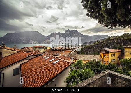 Panorama-Luftaufnahme von Riva Del Garda Dächer und Stadtbild gegen Gardasee See und Berge vor einem schweren Sturm während eines Wintertages, Trentino Alto Adig Stockfoto