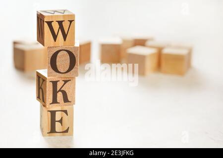 Vier Holzwürfel im Stapel angeordnet mit Wort WOKE (steht für Wisdom Opportunity Knowledge and Empowerment) darauf, Platz für Text / Bild bei unten r Stockfoto