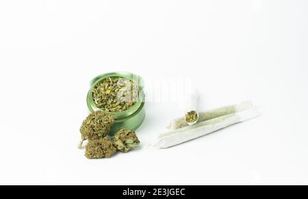 Knospen von Marihuana, Grinder mit zerquetschtem Cannabis und gerollten Gelenken auf weißem Hintergrund.Medizin- und Medizinkonzept.Selektiver Fokus mit Copy Spa Stockfoto