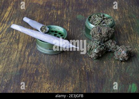 Knospen von Marihuana, Mühle mit zerkleinerten Gras Cannabis und rollte Gelenke auf kreative abstrakte hölzerne background.Medical und Medizin, Freizeit, wir Stockfoto